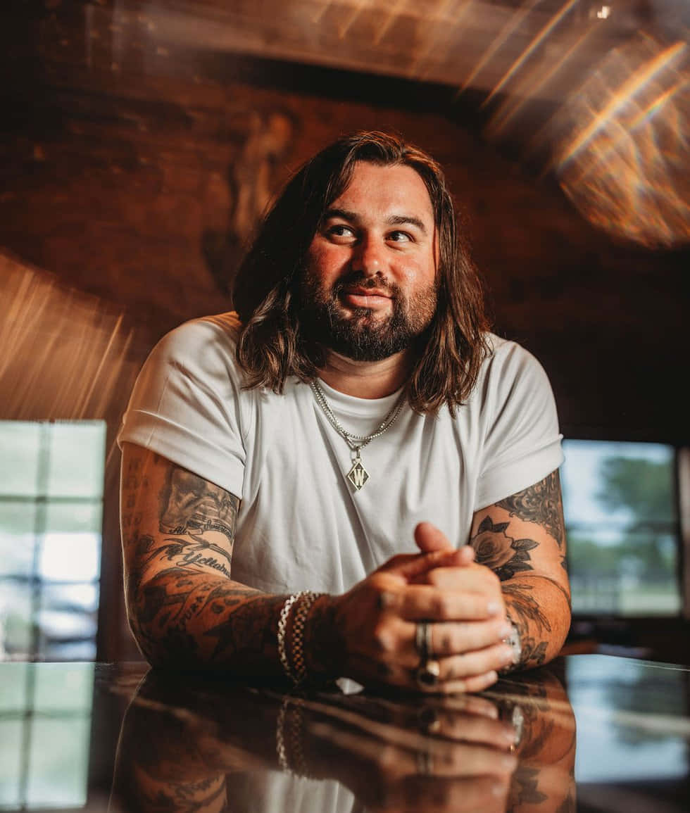 Koe Wetzel smiling with tattooed arms