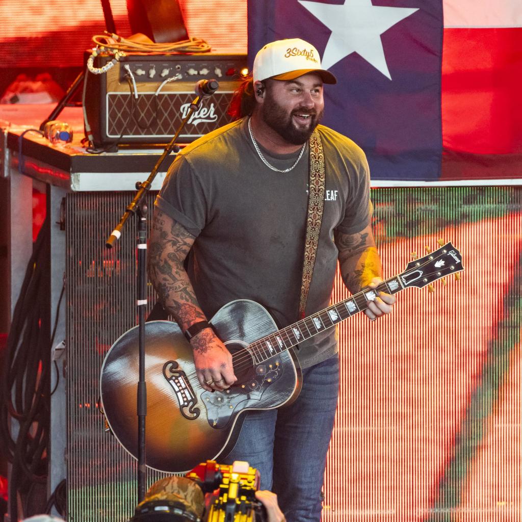 Koe Wetzel playing guitar with tattooed arms