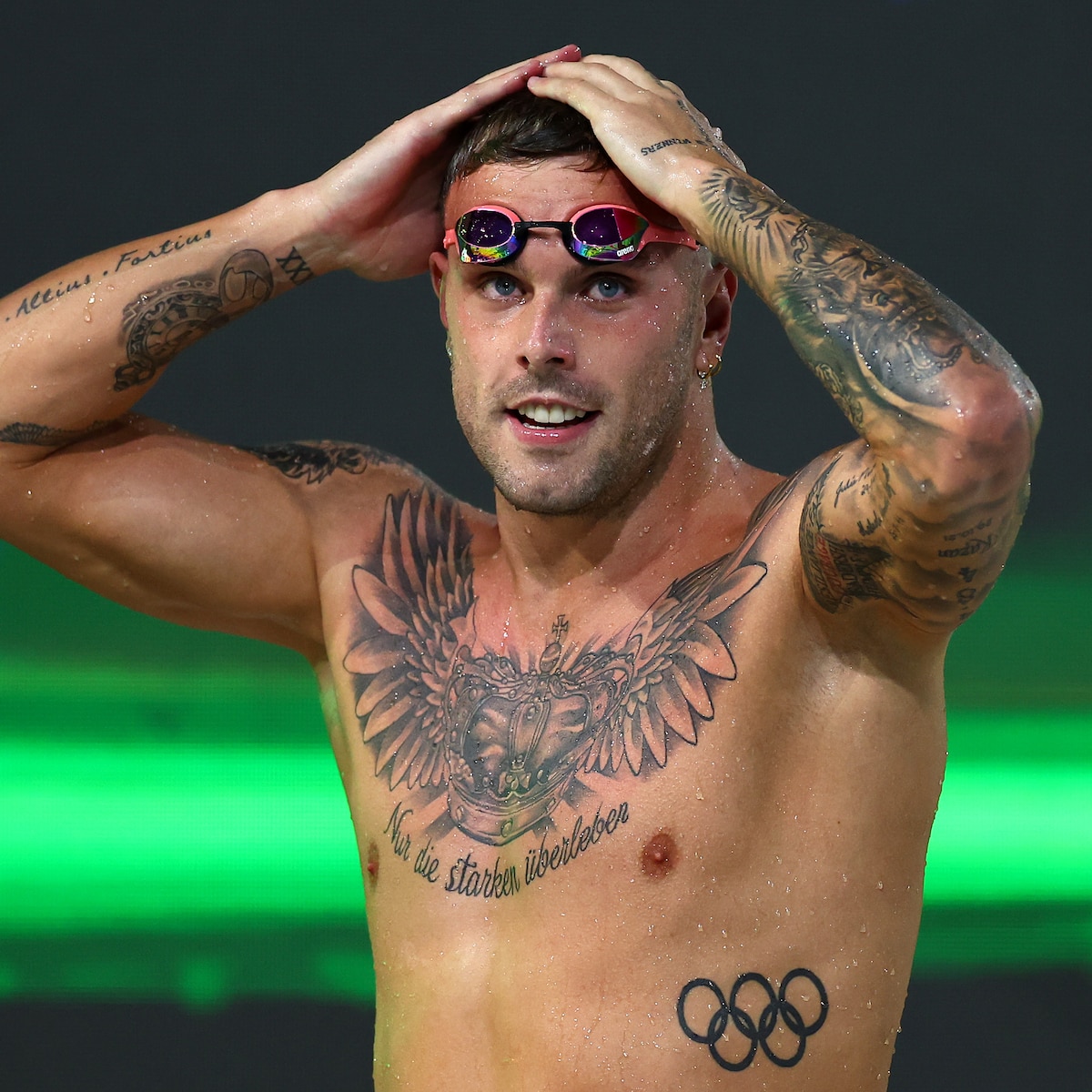 Kyle Chalmers tattoos: Close competition portrait of the chest crown, phrase and forearm tattoos