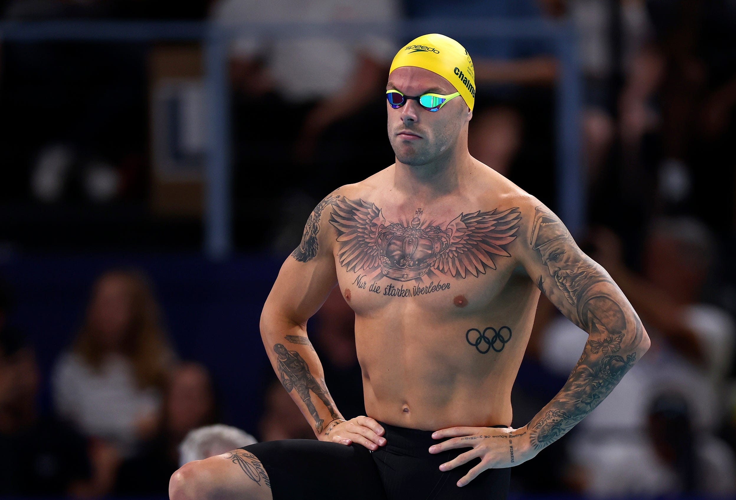 Kyle Chalmers tattoos: Seated Paris pool-deck view of the chest tattoo and arm ink