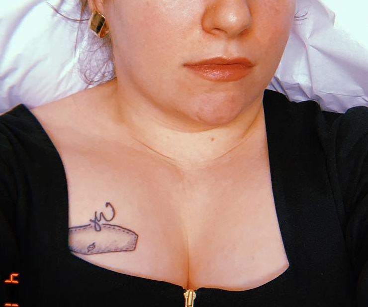 Lena Dunham tattoos: clear close-up of the small chest design peeking above the neckline, with the placement easy to identify