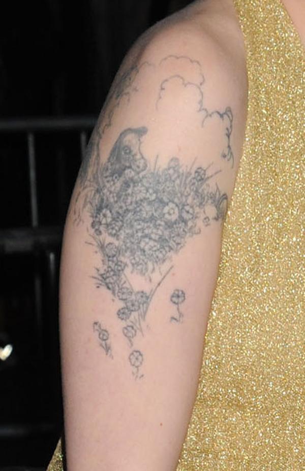 Lena Dunham tattoos: close-up of the fine-line Ferdinand bull surrounded by flowers on the upper arm