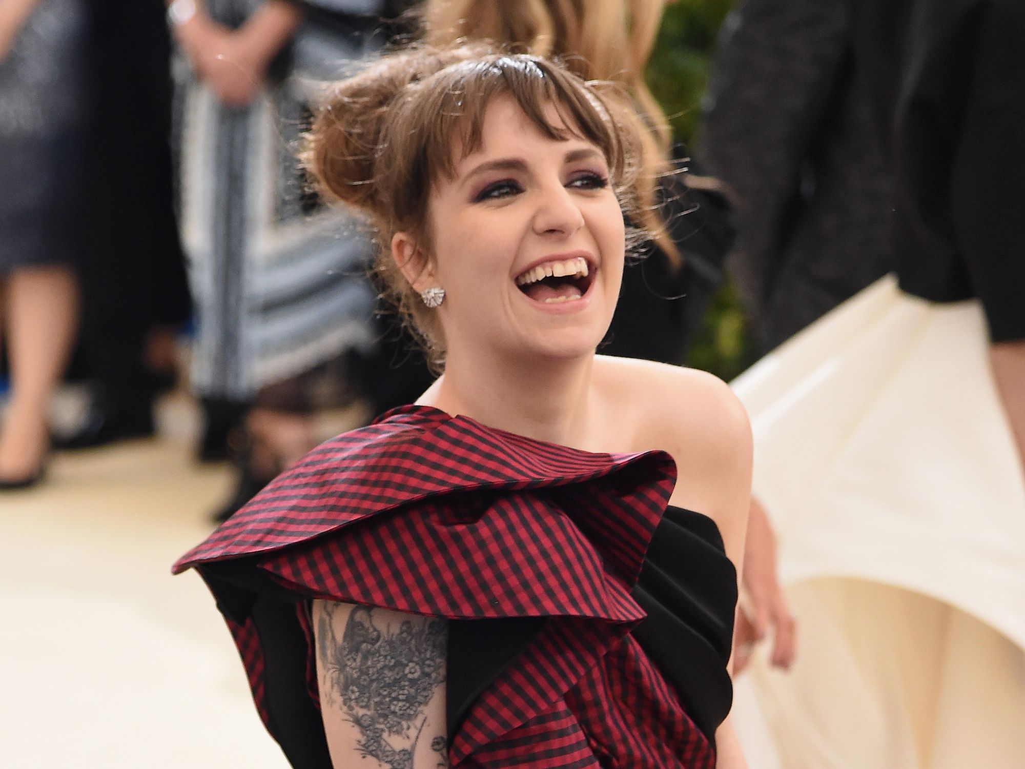 Lena Dunham tattoos: high-resolution red-carpet photo showing the floral upper-arm tattoo clearly