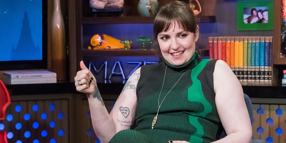 Lena Dunham tattoos: clean talk-show portrait where the heart-shaped LOVE ME arm tattoo and nearby script are plainly visible