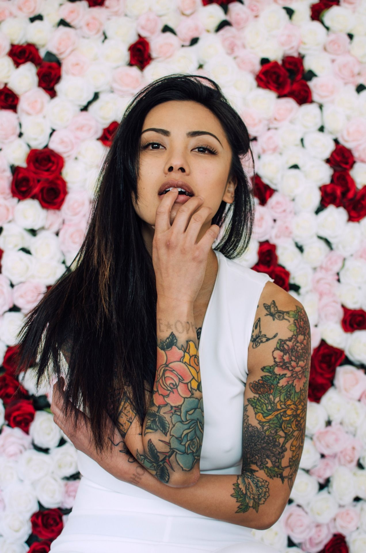 Levy Tran tattoos: Chest heart, script and arm tattoos in a portrait view