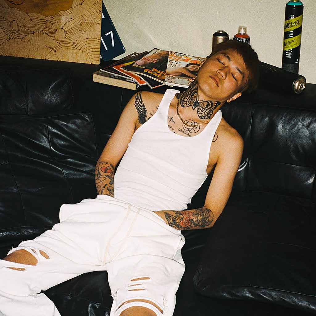 LEX A separate interview portrait showing LEX's chest and arm tattoos, accompanying the family-memory section LEX tattoos: A separate interview portrait showing LEX's chest and arm tattoos, accompanying the family-memory section