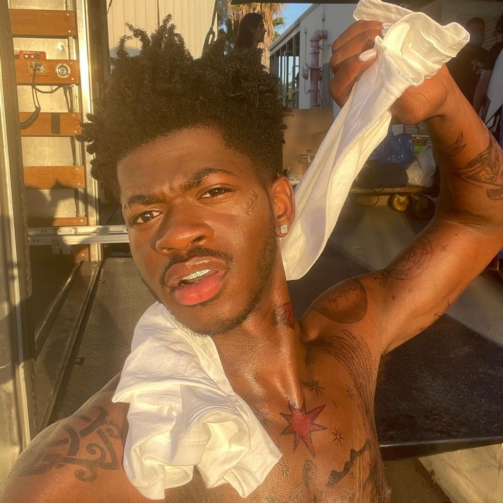 Lil Nas X tattoos: butterfly tattoos across arms and torso
