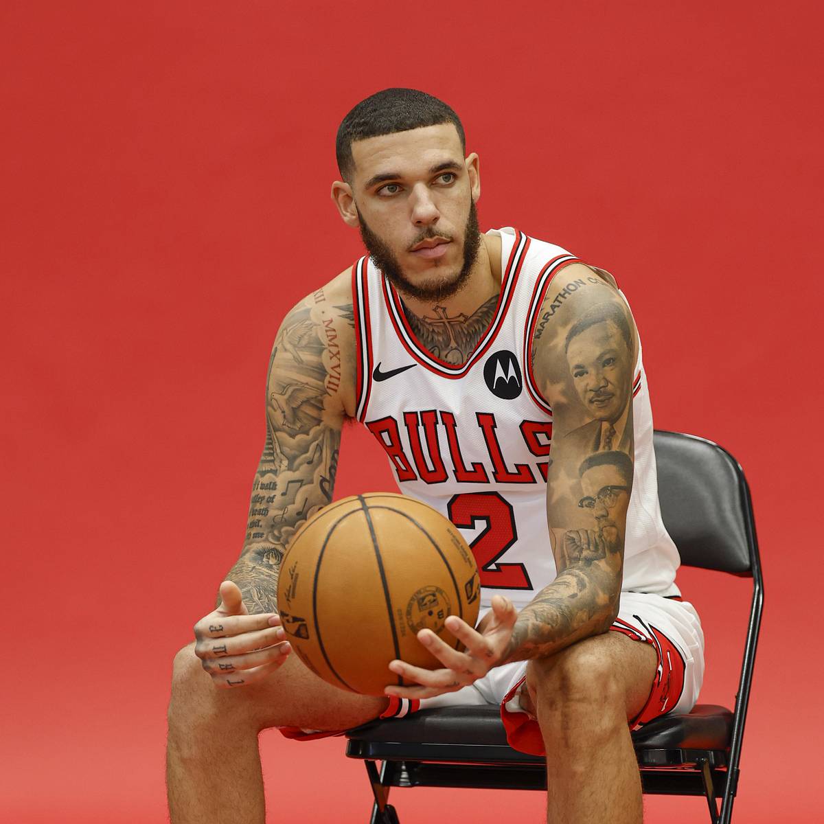 Lonzo Ball tattoos: seated Bulls portrait showing the cross, chest and neck tattoos