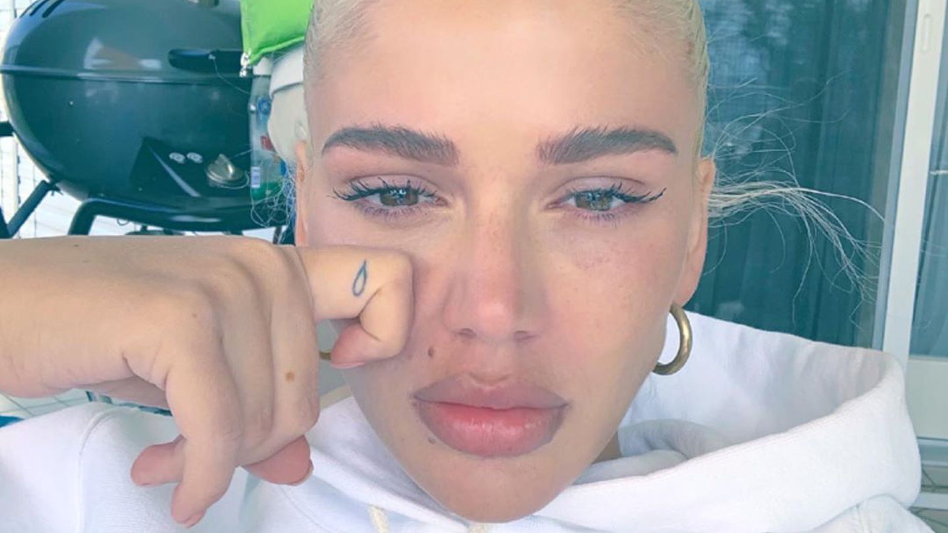 Loredana tattoos: high-resolution close portrait showing the teardrop finger tattoo beside Loredana's face