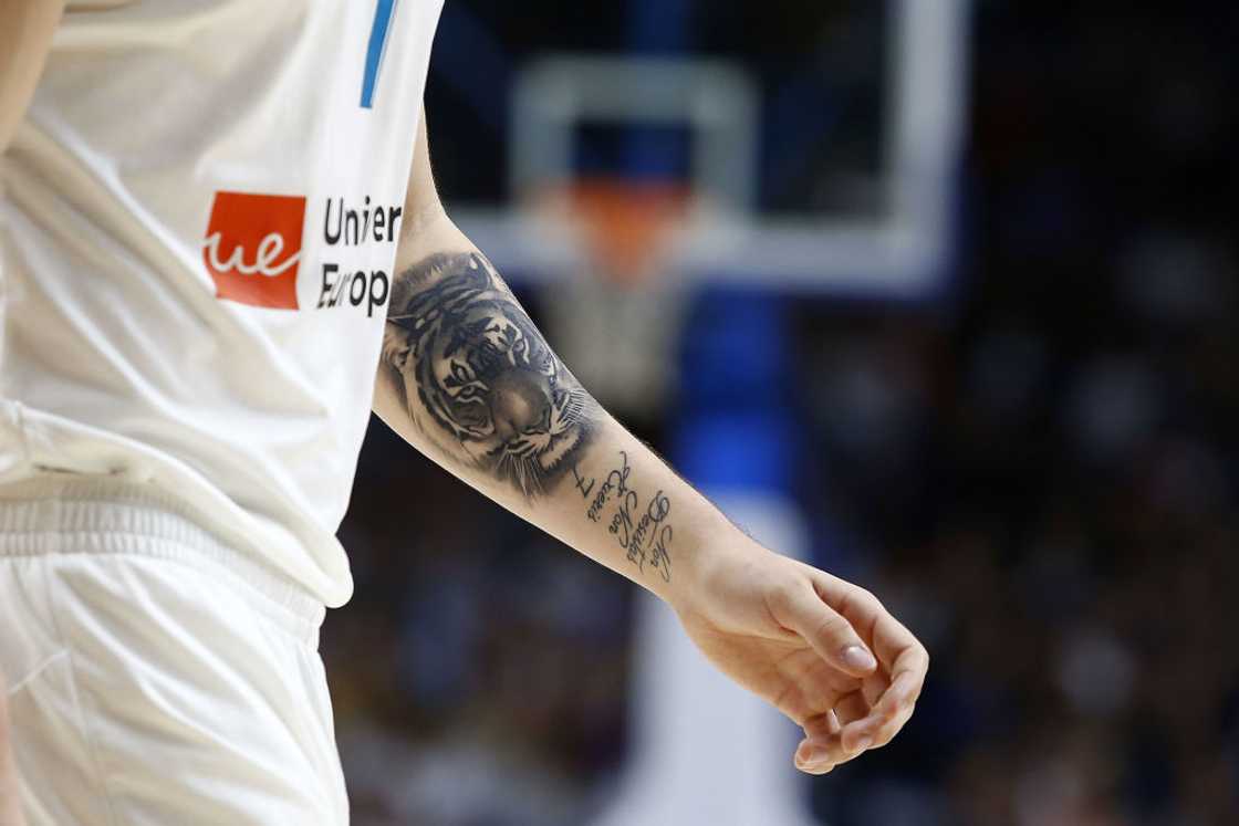 Luka Doncic tattoos: tiger and Latin phrase forearm tattoos