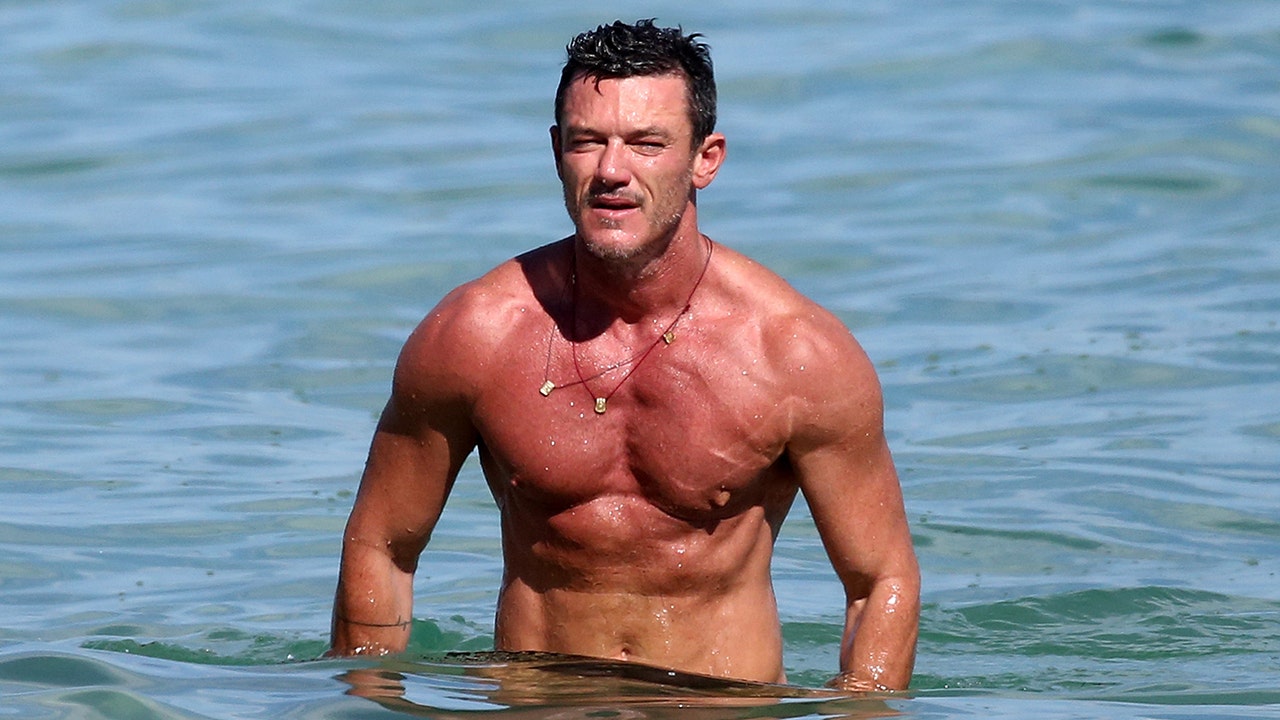 Luke Evans in a contextual photograph: Contextual beach portrait; explicitly not tattoo evidence; not tattoo evidence