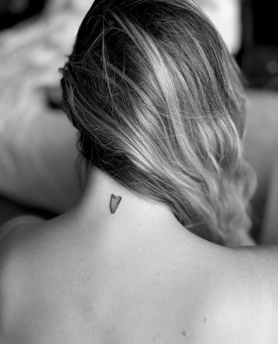 Madelyn Cline tattoos: Close tattoo photograph showing Madelyn Cline's small heart tattoo at the nape of her neck.