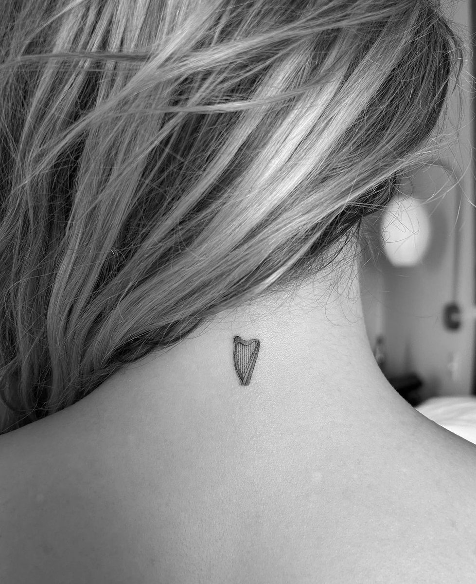 Madelyn Cline tattoos: Tattoo photograph showing the heart nape tattoo from a centered angle with its upper-back placement visible.