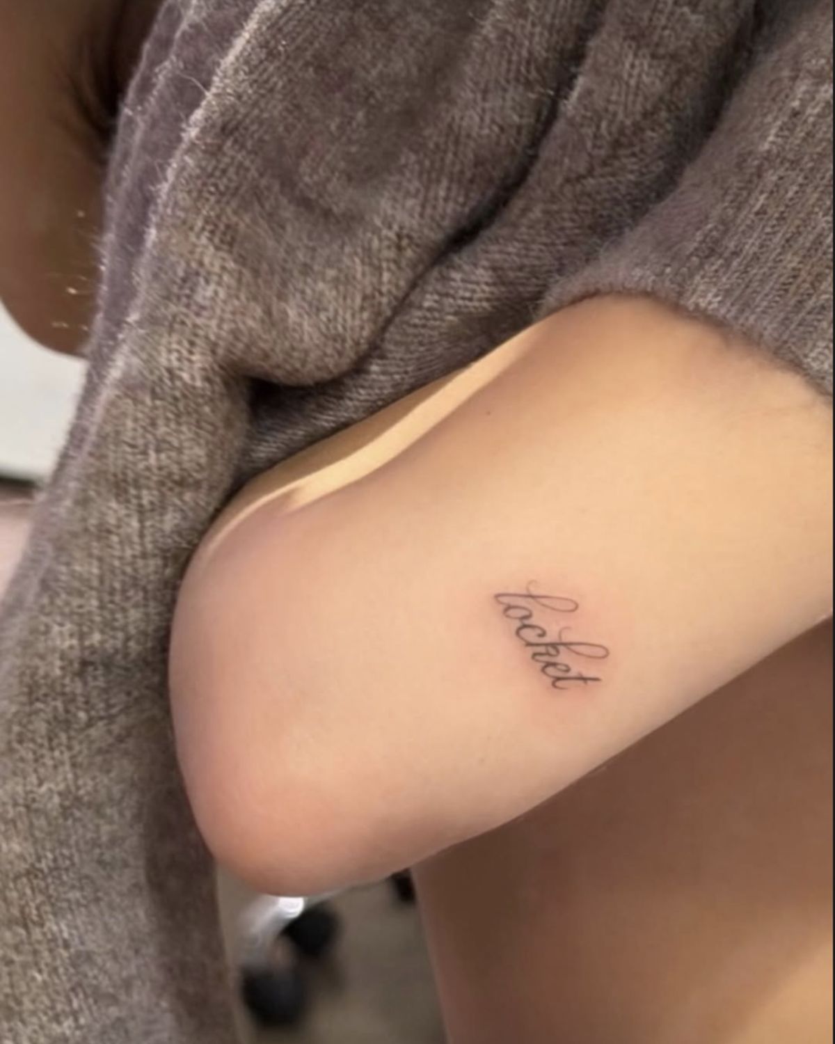 Madison Beer tattoos: Genuine clean view of the ‘locket’ script discussed in this tattoo-specific section; no interface graphics.