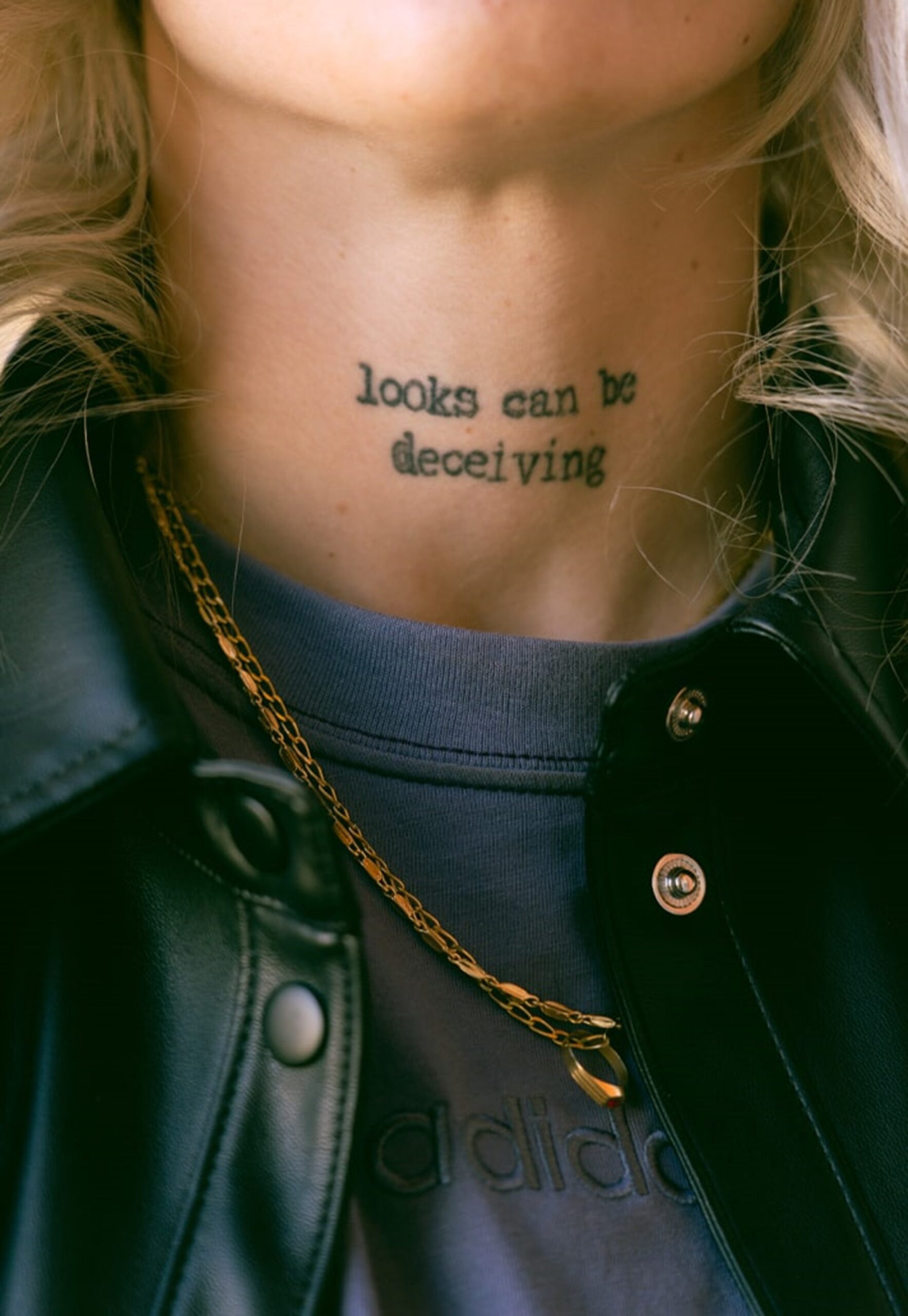 Mapi León neck lettering tattoo Mapi León tattoos: Close view of the two-line neck lettering and its centered placement beneath the chin