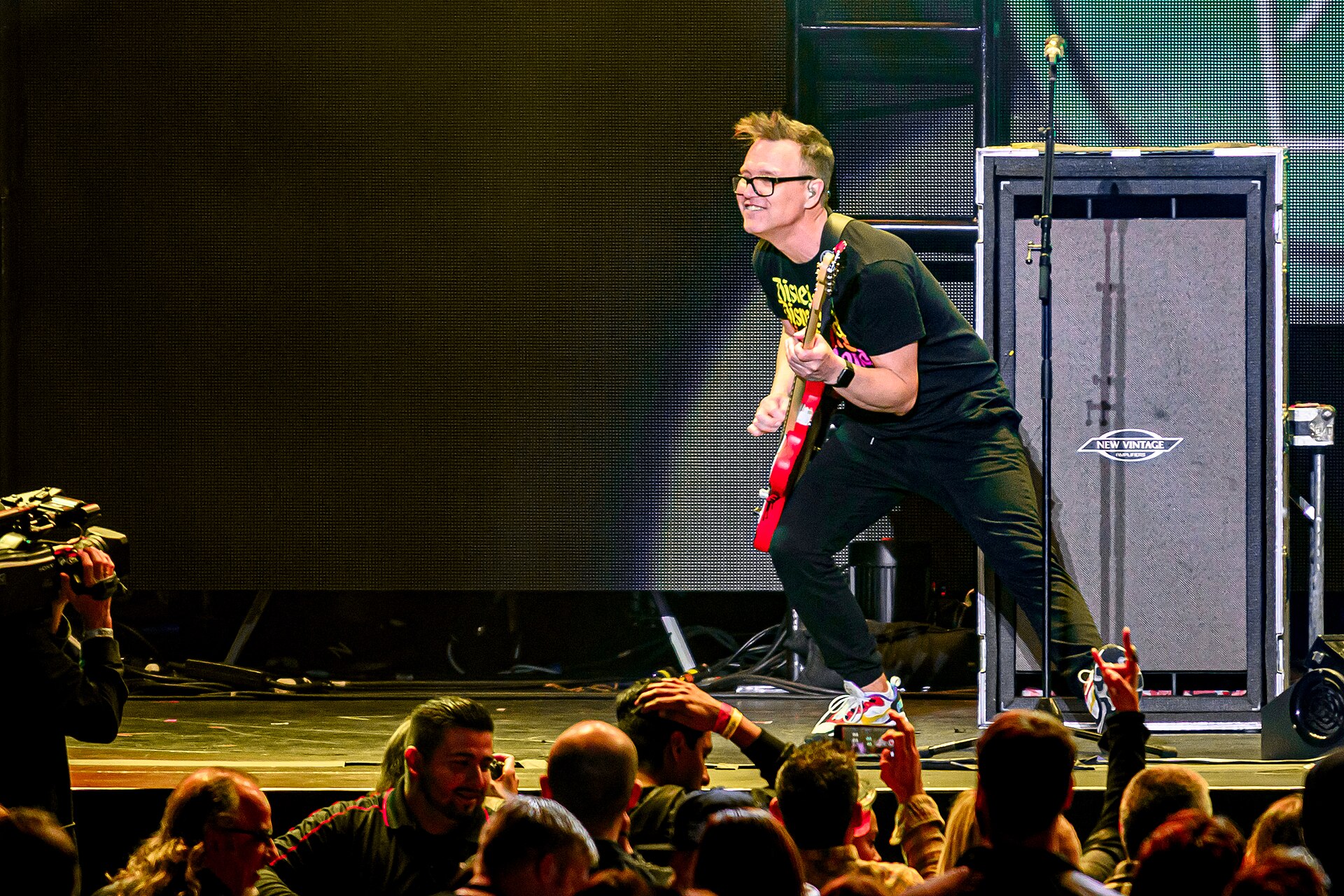Mark Hoppus in a contextual photograph: concert contextual photograph, no tattoo evidence; not tattoo evidence