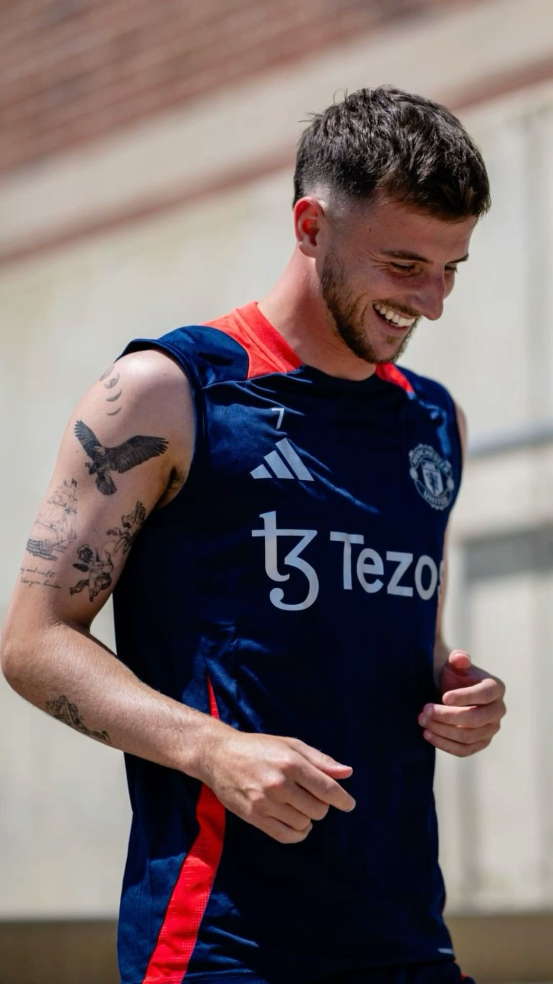 Mason Mount tattoos: Tattoo evidence: high-resolution training portrait with the eagle and surrounding black-ink arm pieces visible beneath a sleeveless top.