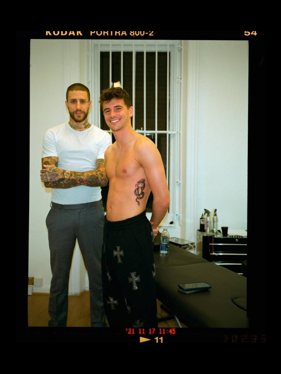 Mason Mount tattoos: Tattoo evidence: padded presentation of the distinct session photograph showing Mount shirtless beside the tattoo artist with the abdominal piece visible.