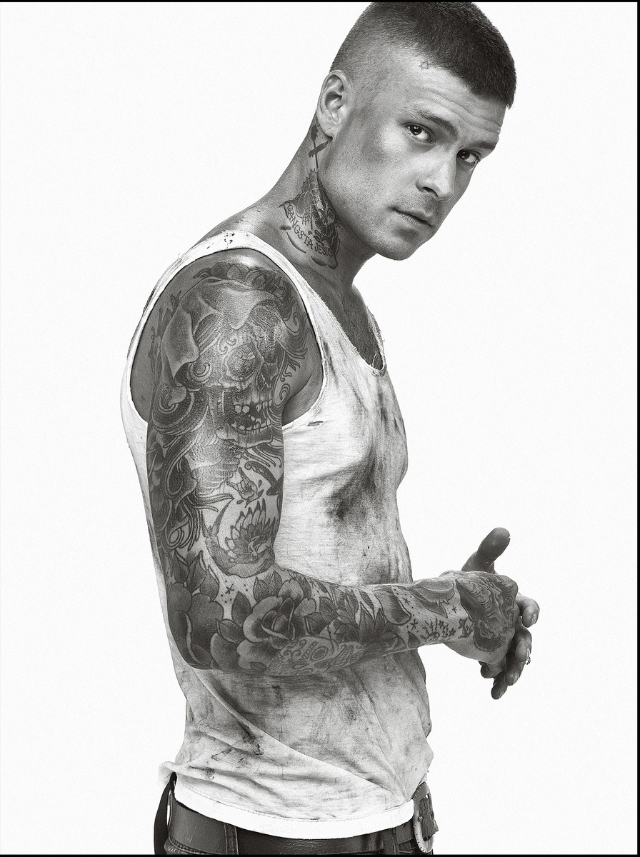 Mateus Verdelho tattoos: Skull, curling lines, rose and flame-like upper-arm design