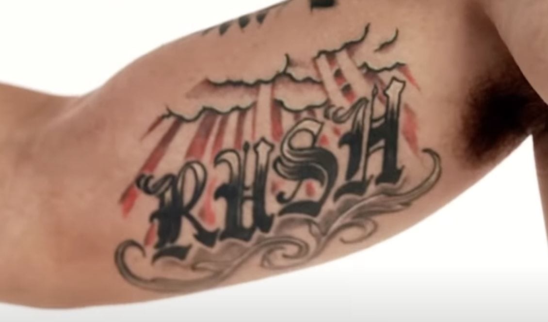 Max Holloway RUSH Inner Bicep Tattoo Max Holloway tattoos: RUSH lettering and cloud-and-ray imagery honoring his son