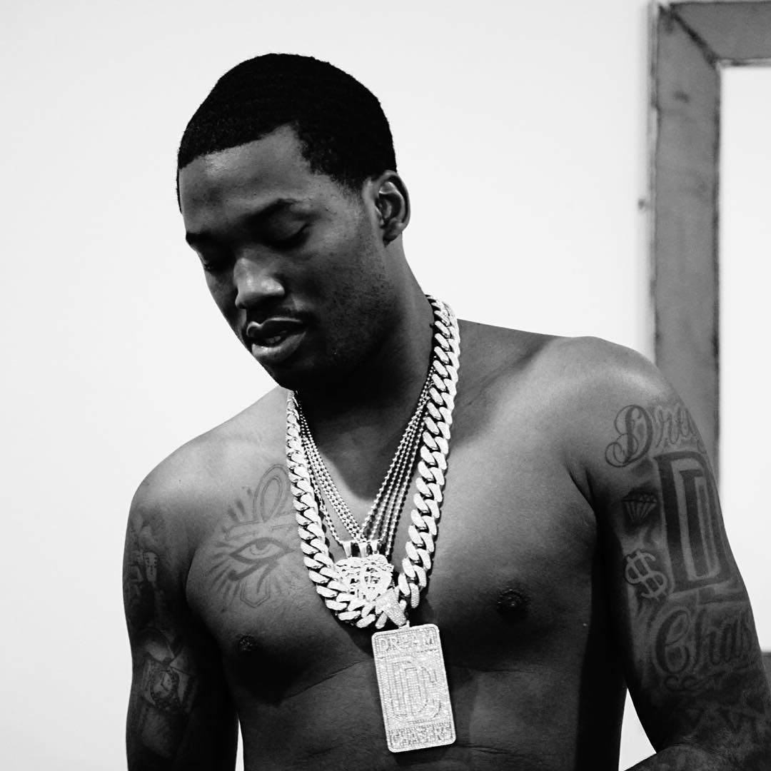 Meek Mill tattoos: shirtless chest view showing the Eye of Horus, ankh and upper-arm tattoos
