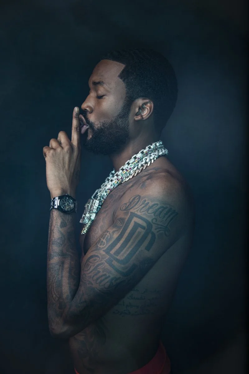 Meek Mill tattoos: side portrait showing the lower chest lettering and outer-arm tattoos