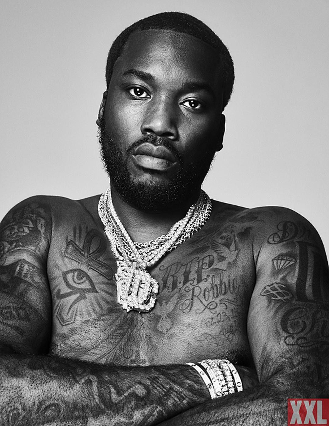 Meek Mill tattoos: shirtless portrait showing the memorial chest lettering and both tattooed arms