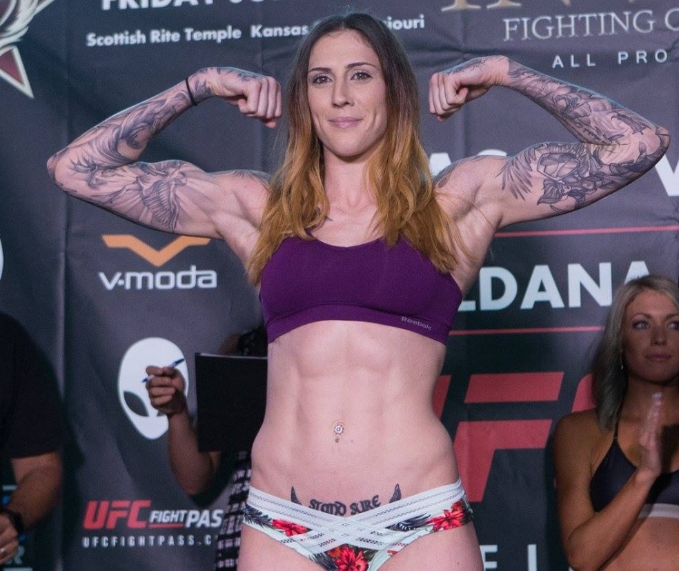 Megan Anderson tattoos: purple weigh-in view with floral arm work, side ink and lower-abdomen tattoo