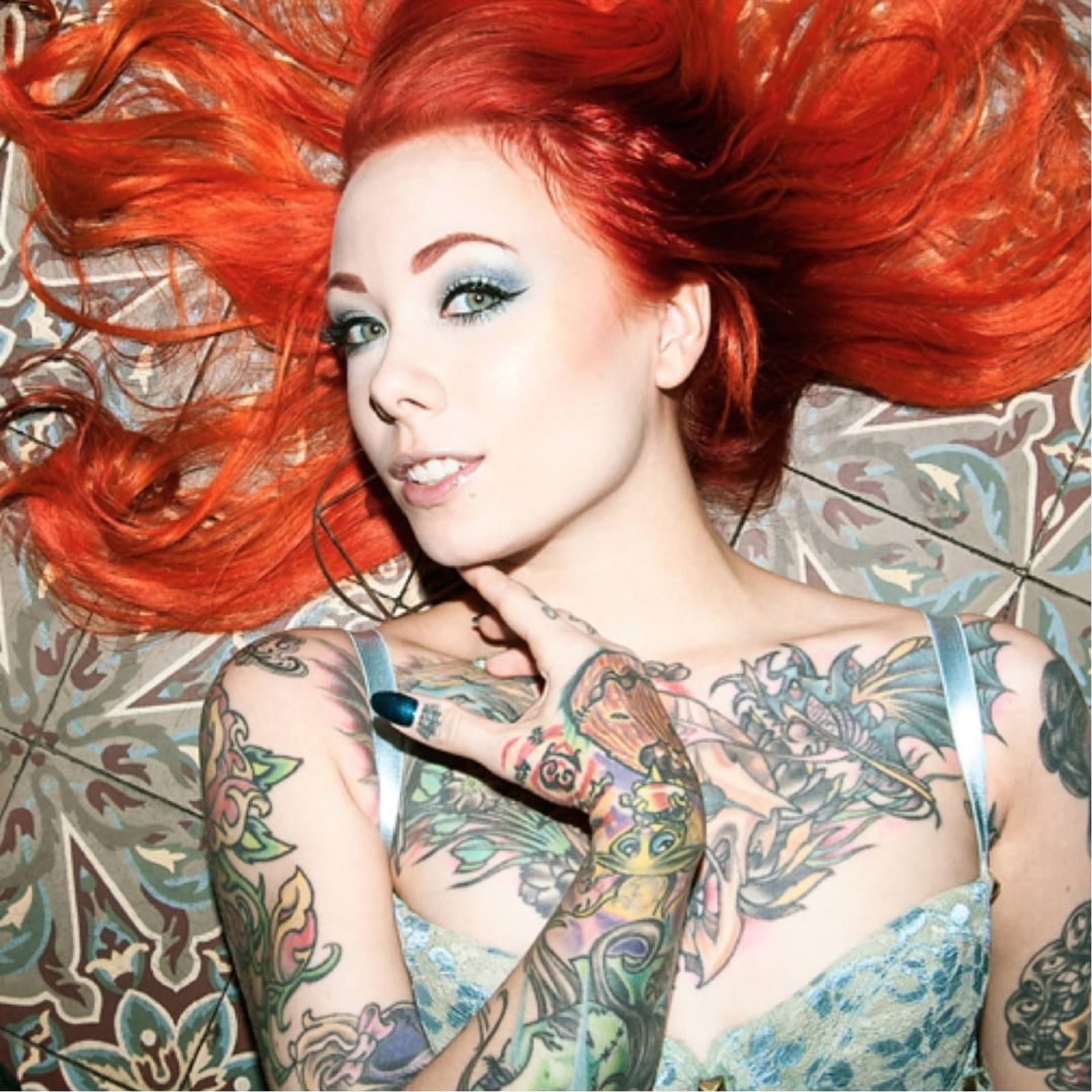Megan Massacre tattoos: high-resolution chest and arm view showing colorful illustrative tattoos