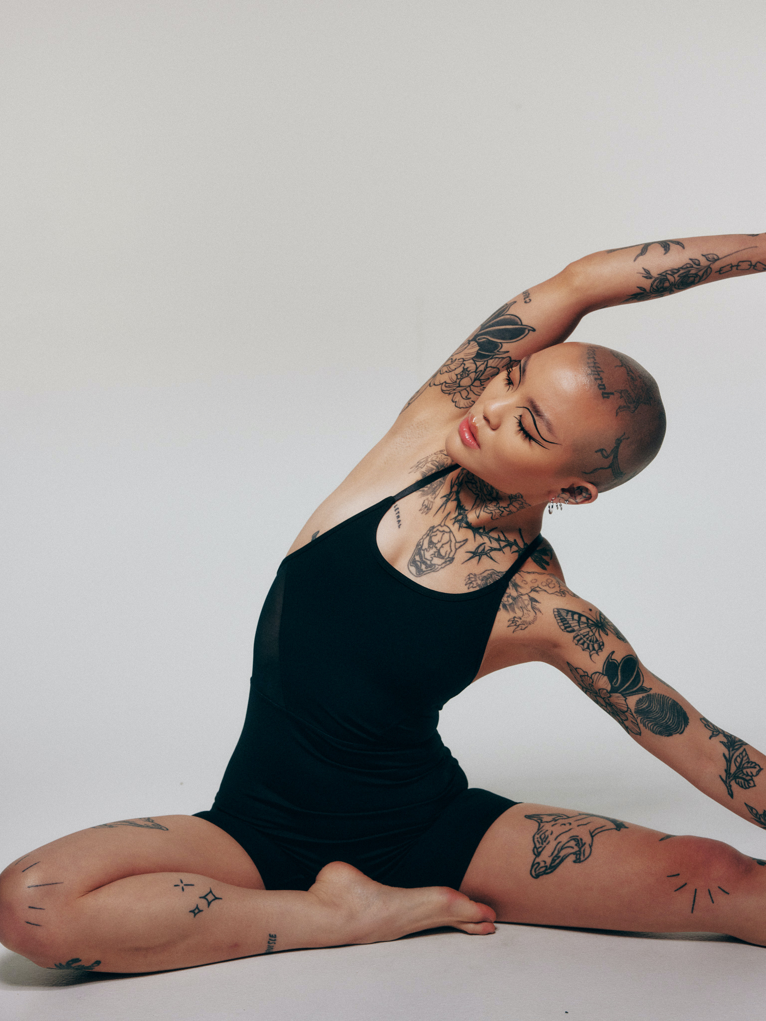 Mei Pang tattoos: side portrait showing collarbone, neck, arm and thigh tattoo placement
