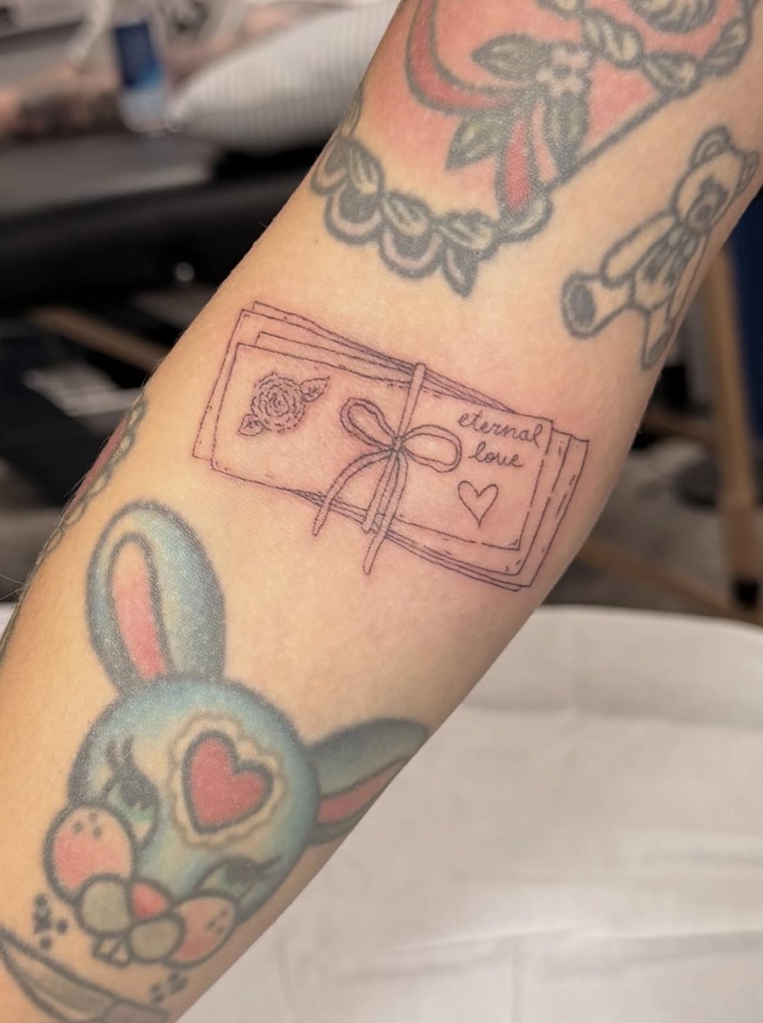 Melanie Martinez arm tattoos with bunny and eternal love letter