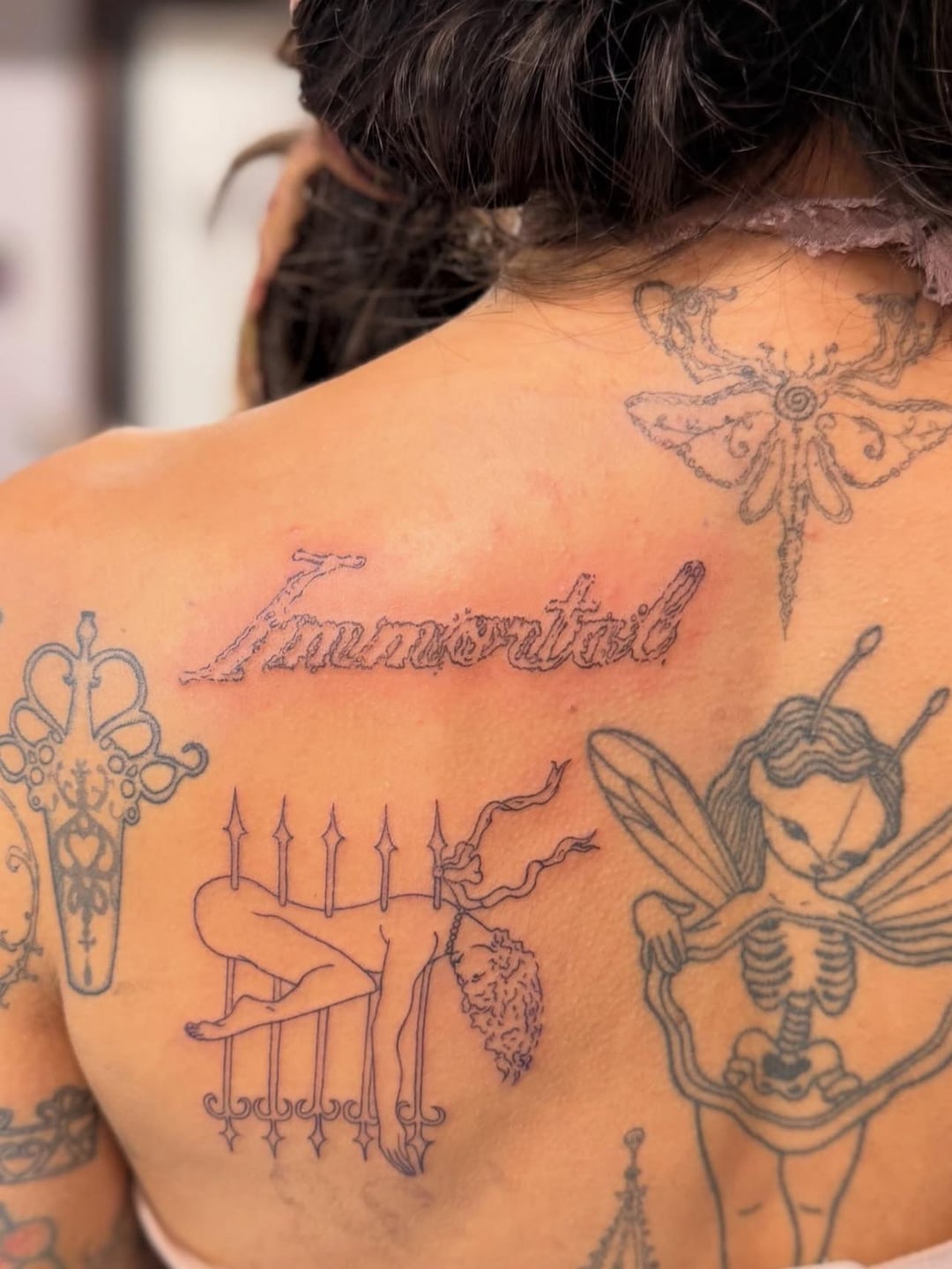 Melanie Martinez fine line back and shoulder tattoos