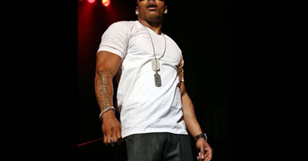 Nelly tattoos: clear event photograph showing the dripping chest rose and script across the stomach