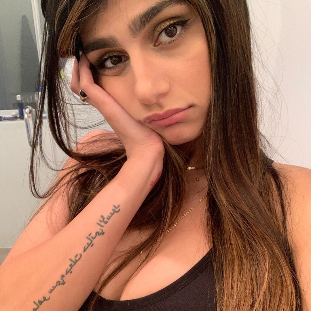 Mia Khalifa tattoos: Arabic forearm script in a clear close portrait