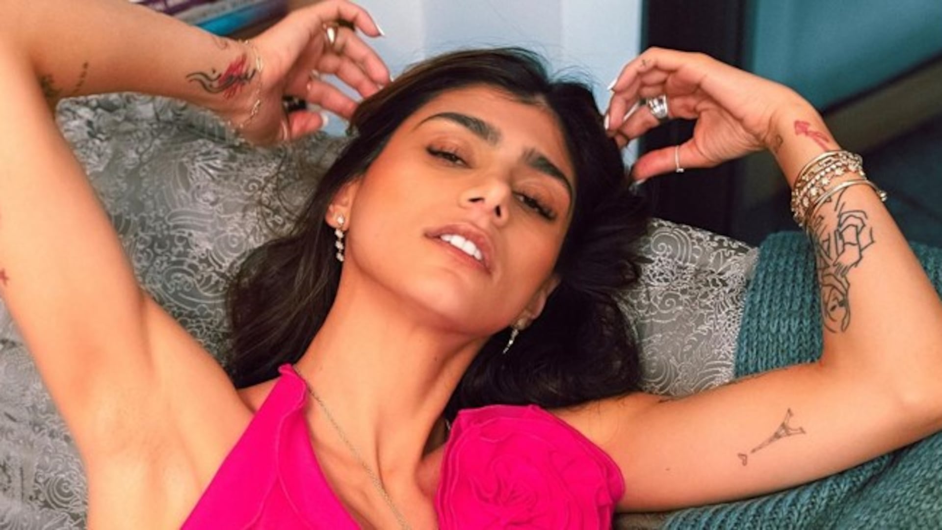 Mia Khalifa tattoos: multiple arm and hand tattoos in a clear raised-arm photograph