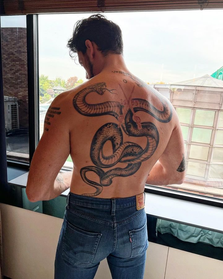 Michele Morrone tattoos: Shows the large snake design across Morrone’s back.
