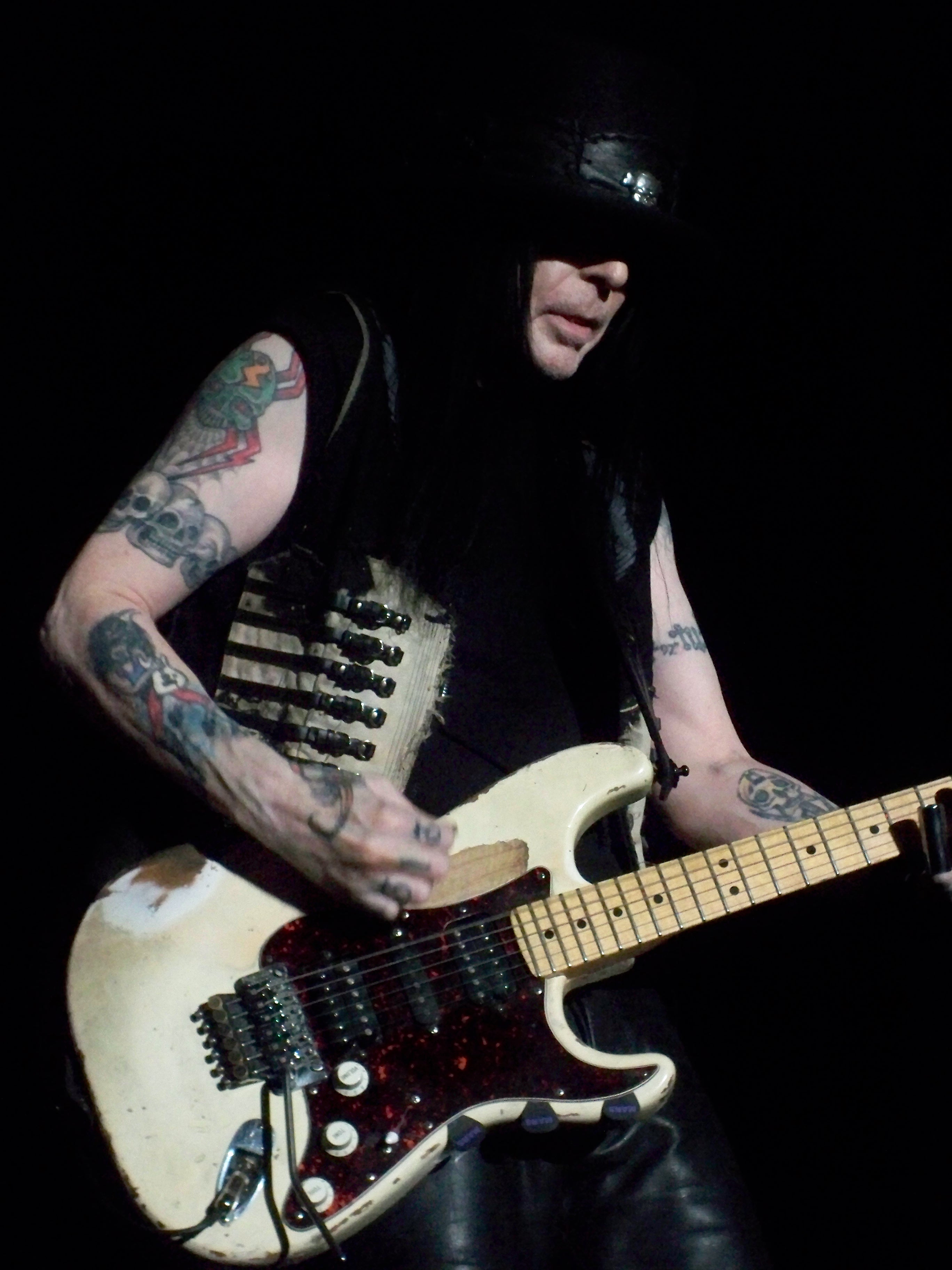 Mick Mars skull and rose upper arm tattoo