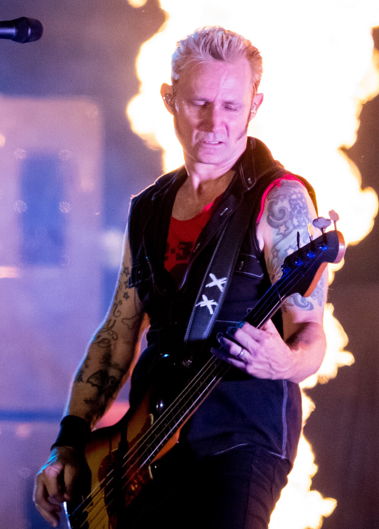Mike Dirnt flame lit arm tattoos during a Green Day show