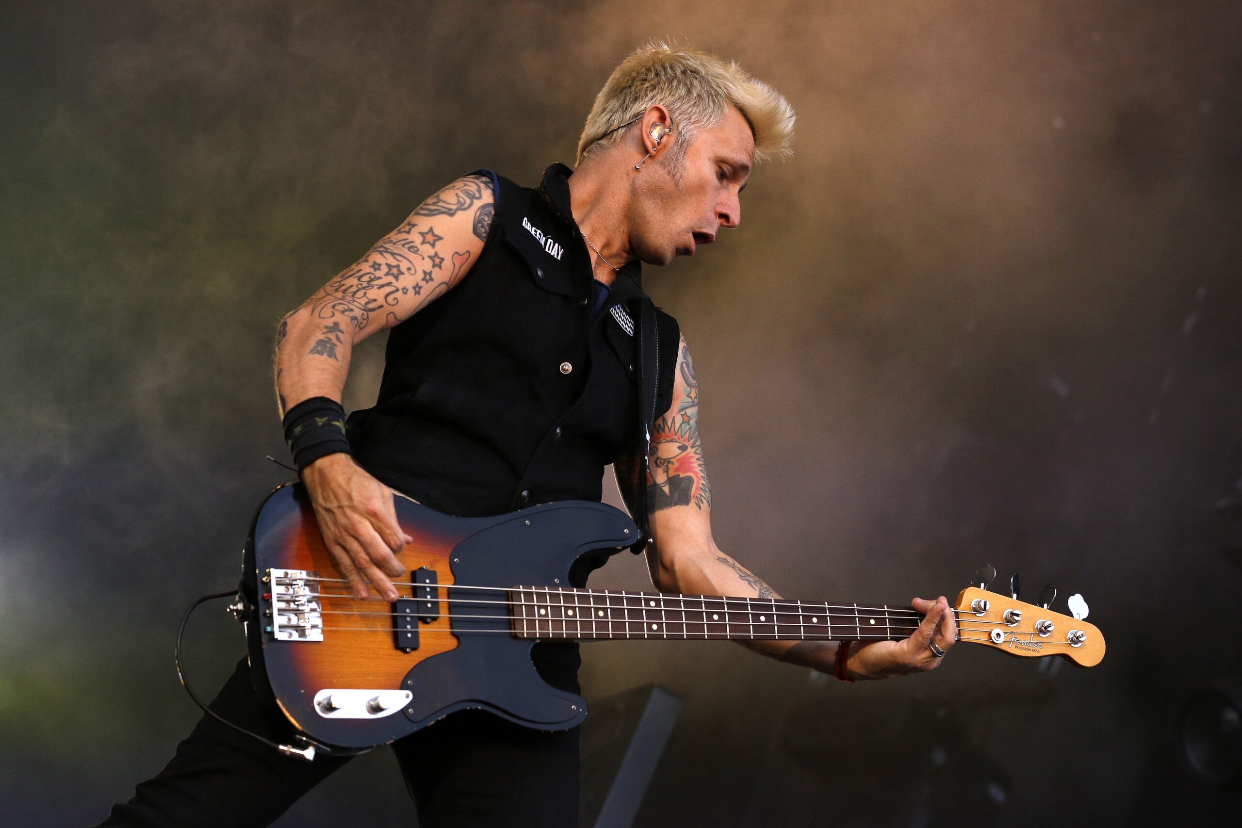 Mike Dirnt star and script tattoos on both arms