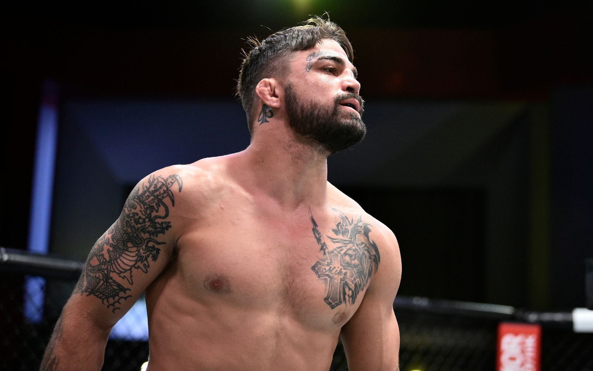 Mike Perry showing his chest cross and Knight of Swords tattoos