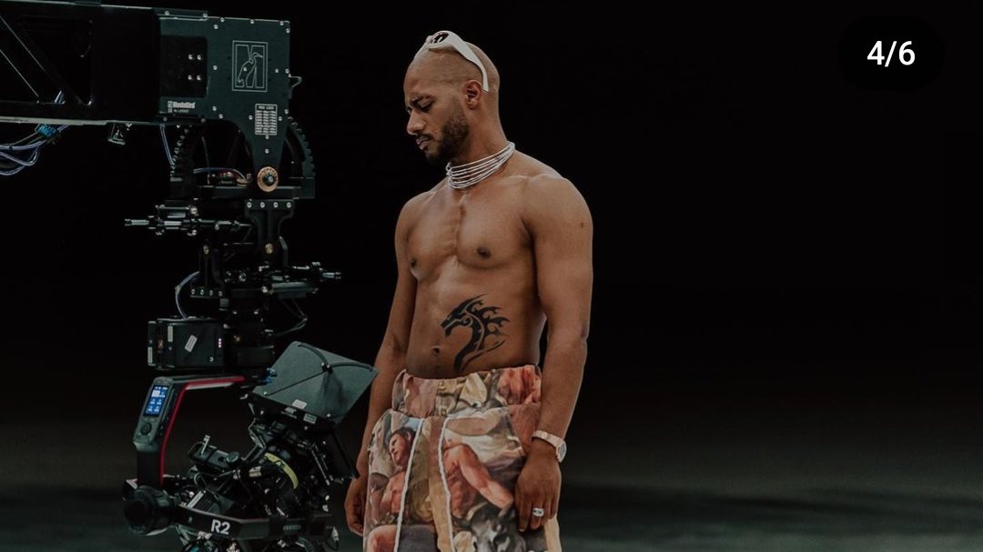 Mohamed Ramadan tattoos: Tattoo evidence: high-resolution view beside a cinema camera with the abdomen dragon clearly visible.
