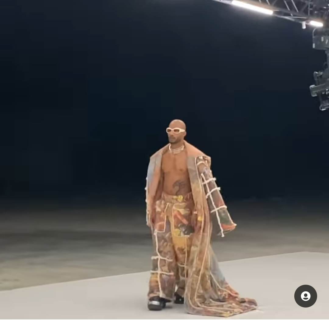 Mohamed Ramadan tattoos: Tattoo evidence: wide walking frame with the dragon visible beneath the open coat.