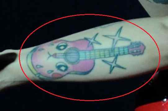 Mon Laferte tattoos: genuine tattoo photograph showing the face guitar and stars