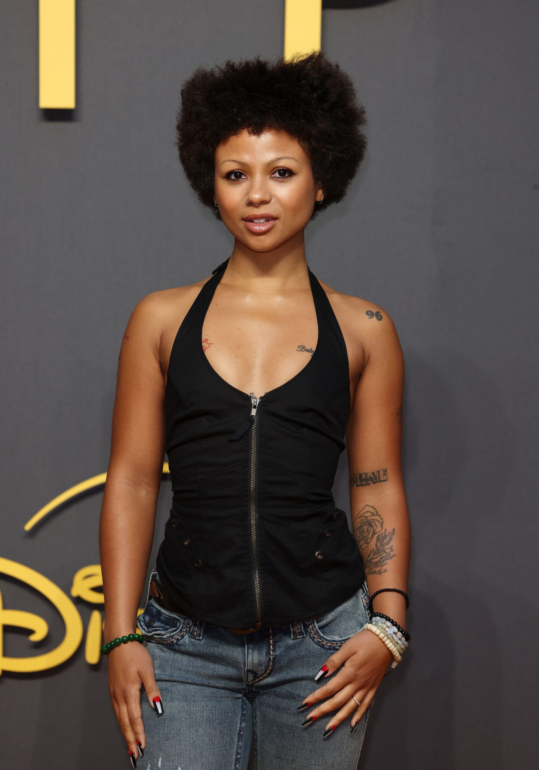 Myha'la tattoos: High-resolution event photograph showing the rose-and-leaf forearm tattoo.