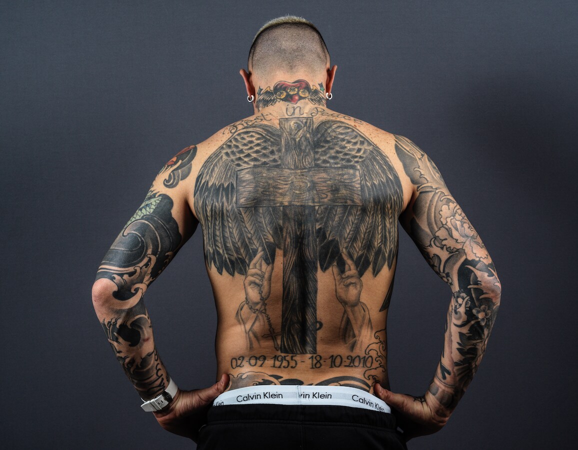 Radja Nainggolan back tattoo with wings, cross and dates