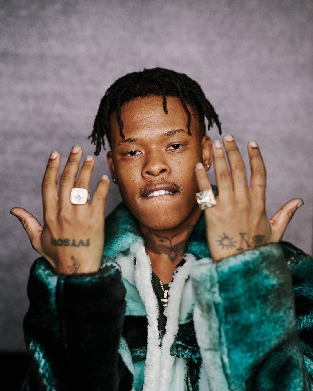 Nasty C tattoos: both hand tattoos in a sharp portrait with rings and a fur coat