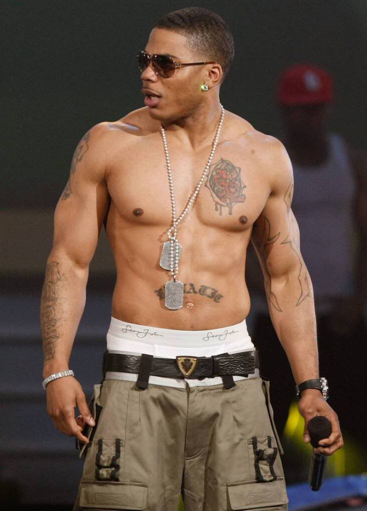 Nelly tattoos: shirtless performance image showing the chest rose, stomach lettering and arm work