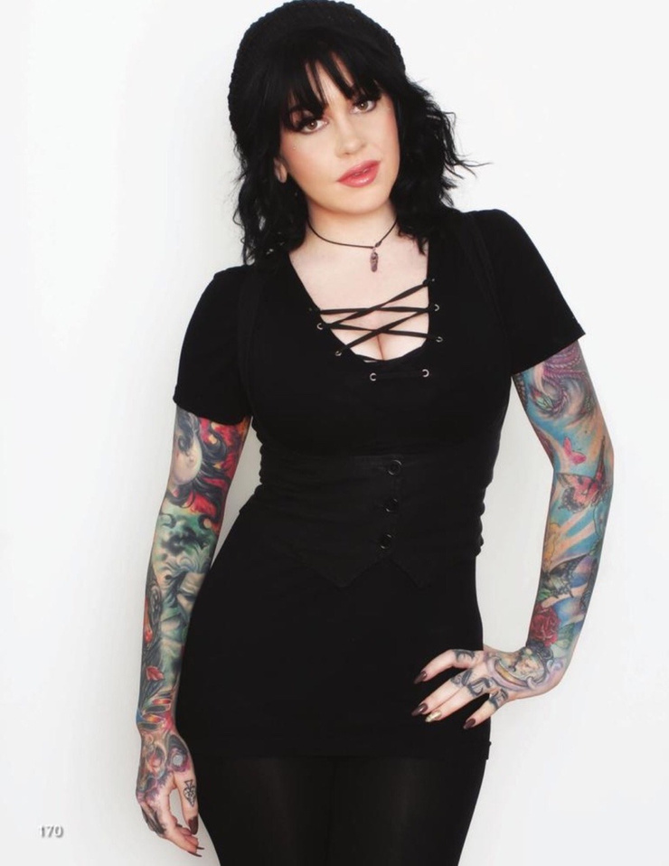 Nikki Simpson tattoos: full-resolution face-visible portrait showing both colourful sleeves from shoulders through the hands