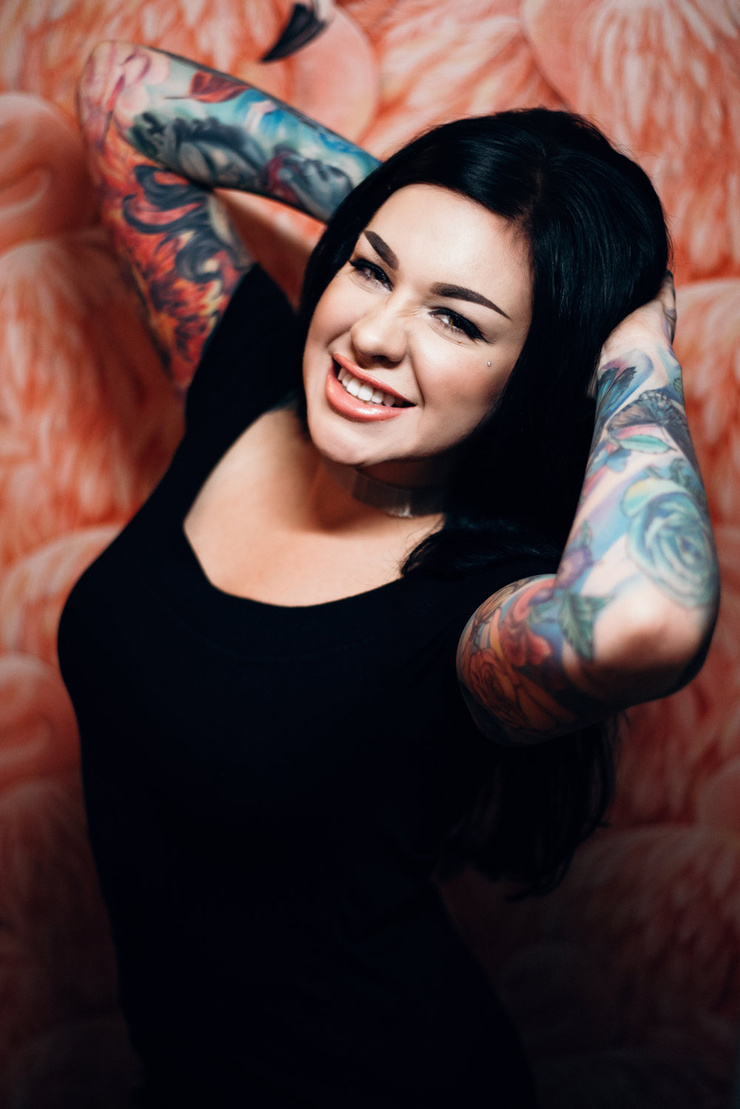 Nikki Simpson tattoos: face-visible close portrait where Nikki's neck tattoos, chest area, and upper-arm ink are easy to inspect
