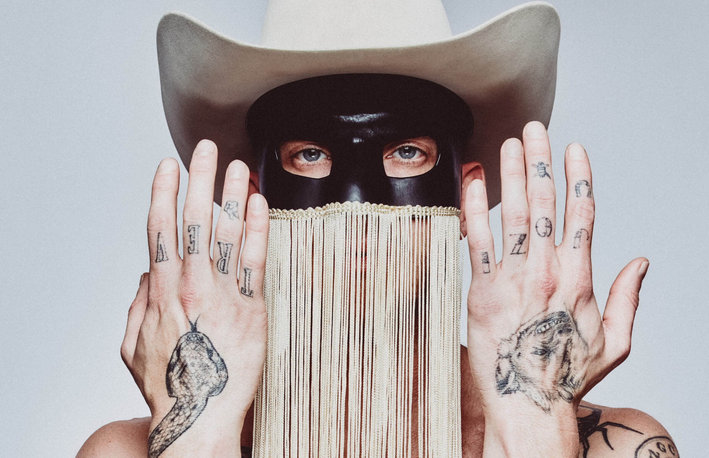 Orville Peck tattoos: close hand photograph showing the knuckle lettering